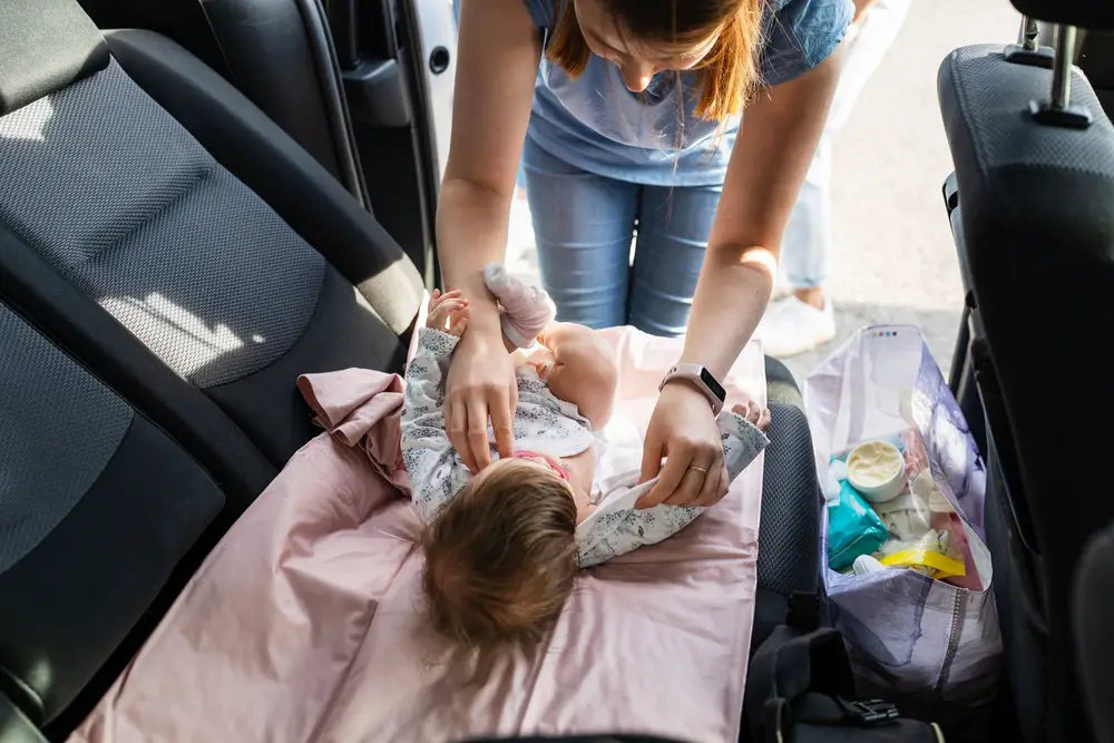 mother changing baby diaper