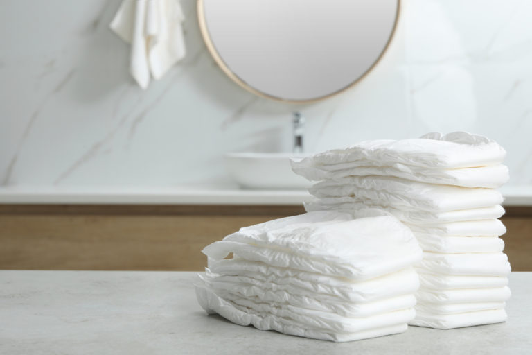 Stacks of baby diapers on counter in bathroom